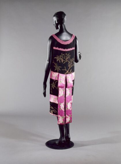 Mannequin wearing a black and pink dress with floral patterns.