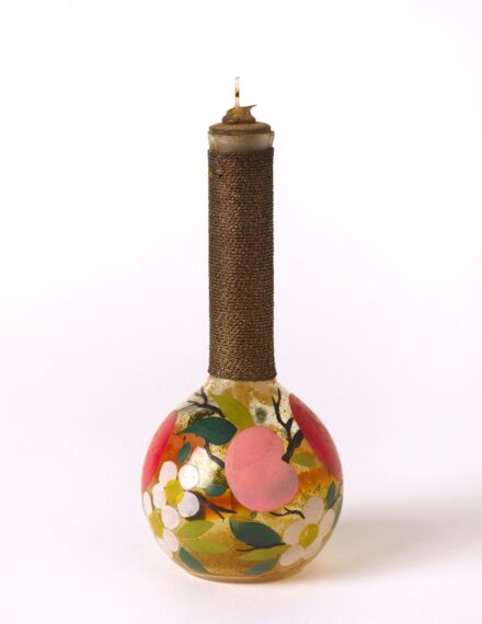 Decorative bottle with floral and fruit design on spherical base.
