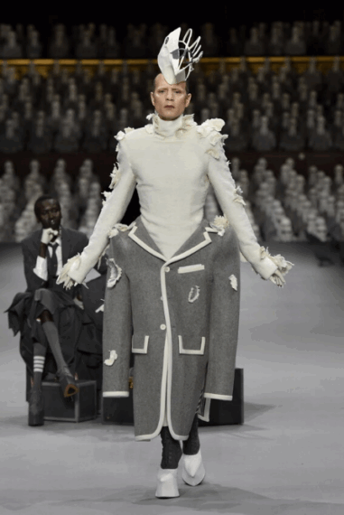 A model walks down a runway wearing an avant-garde fashion ensemble.