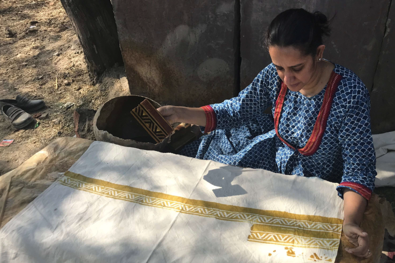 Person in blue dress block-printing cloth outdoors