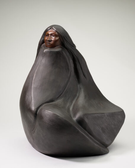 The image shows a sculpture of a figure seated with a flowing, rounded form.