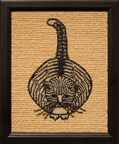 Beaded cat design on tan background in black frame