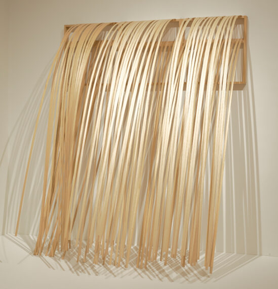 Wooden strips draped over a rectangular frame on a wall.